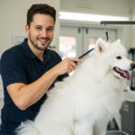 a happy dog groomer combing a white dog on a grooming table